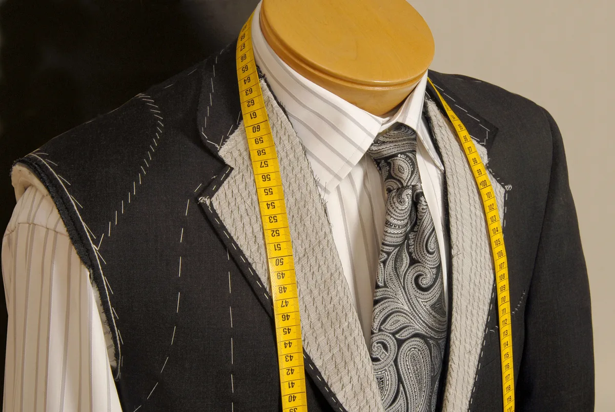 Suit in progress on a tailor's mannequin with measuring tape